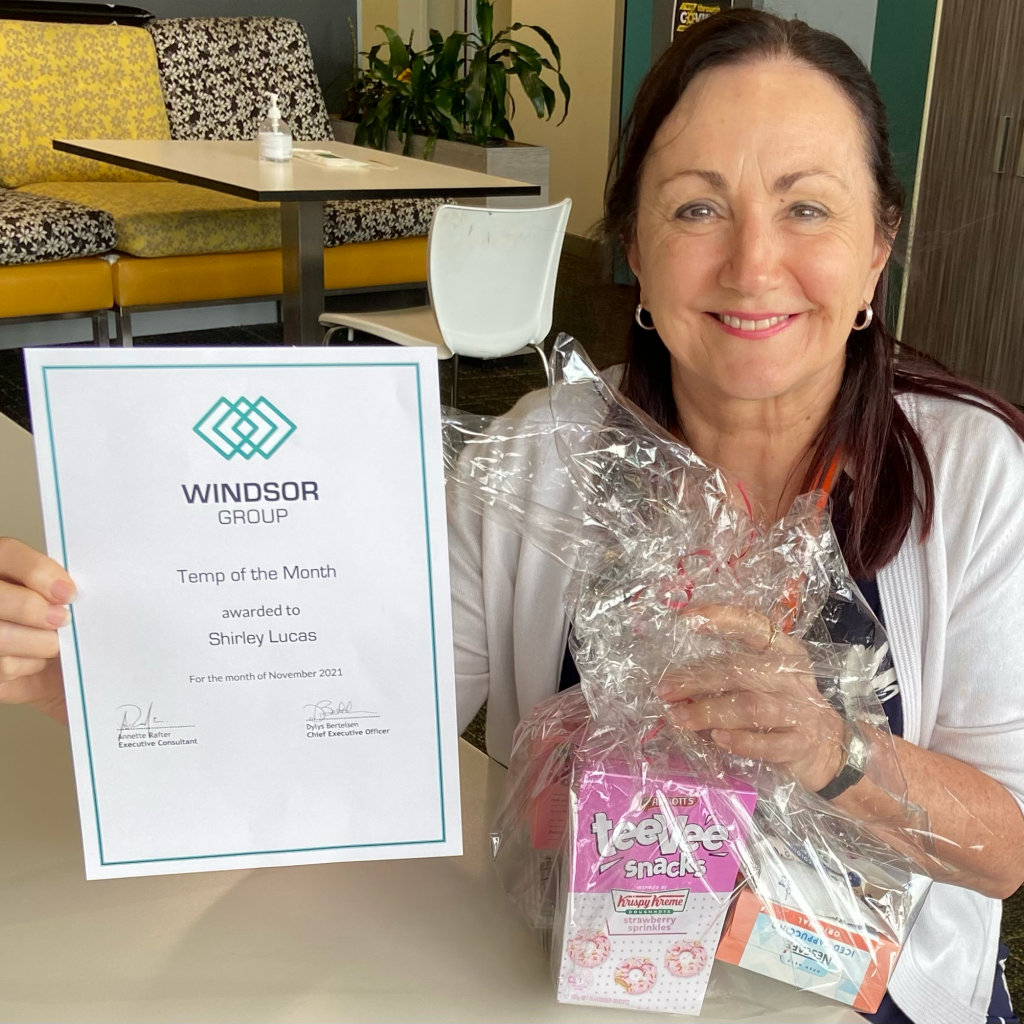 Shirley Lucas holding her Temp of the Month certificate and hamper