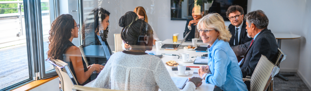 High-functioning Board sat around board table 
